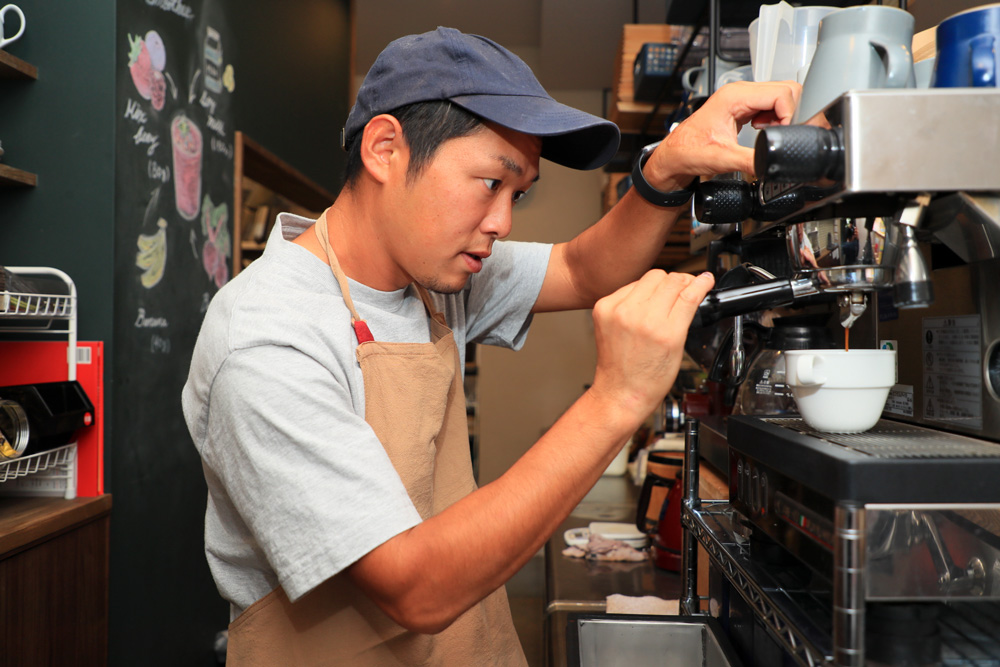 自身が経営するカフェでコーヒーを淹れる林亮輔さん